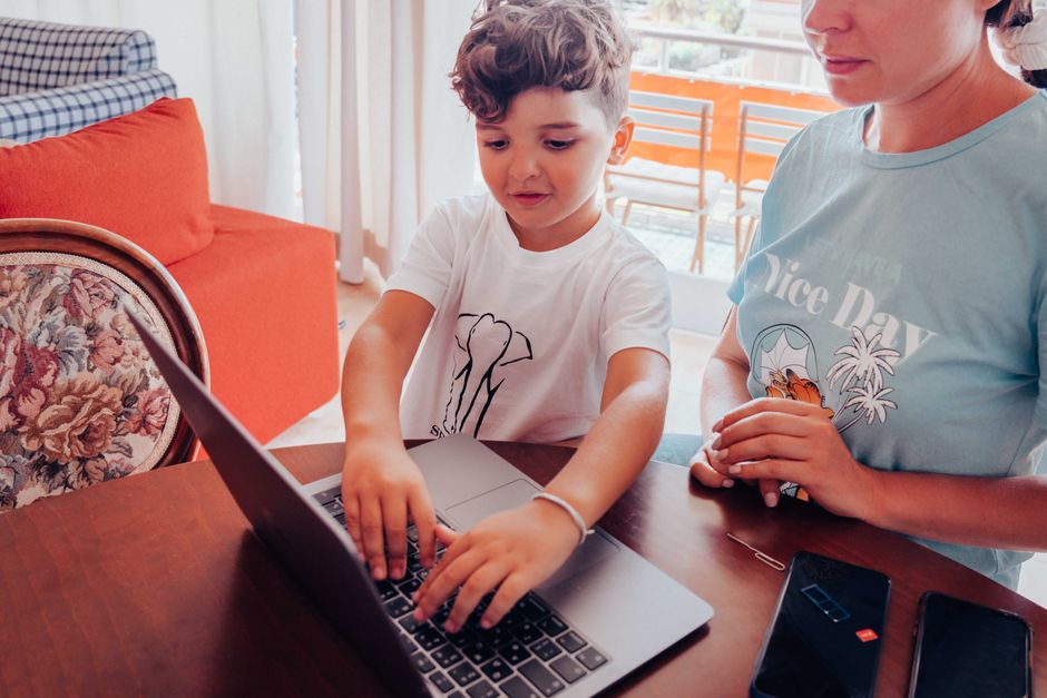 A parent and child using a laptop together