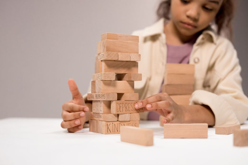 A child building a tower of wooden blocks